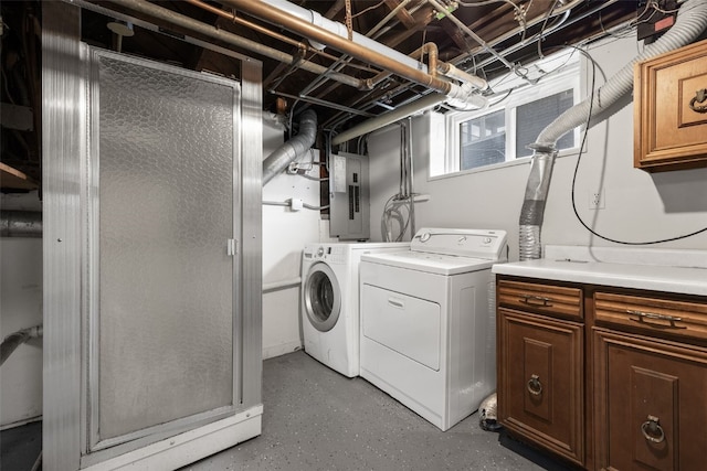 washroom featuring cabinet space, washing machine and dryer, and electric panel