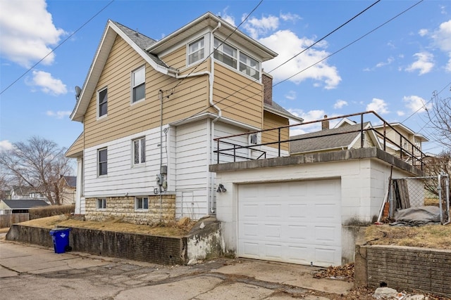 exterior space featuring a garage and a balcony