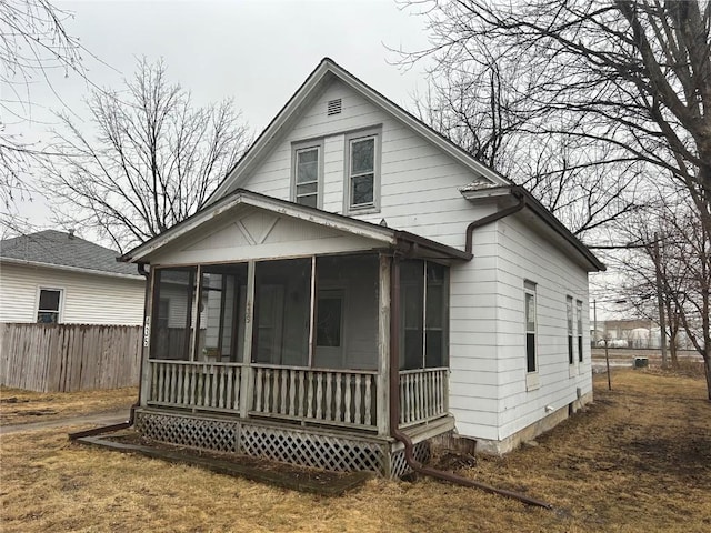 view of front of property featuring fence and a sunroom