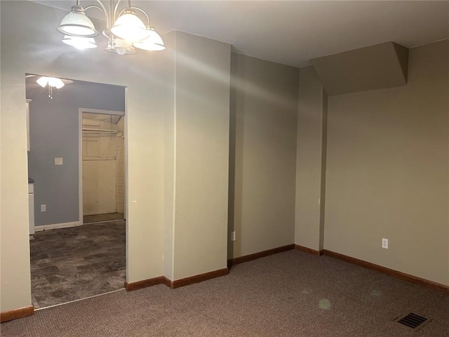 spare room featuring carpet flooring, visible vents, and baseboards