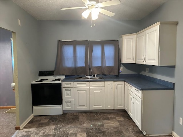 kitchen featuring dark countertops, white cabinetry, a sink, and electric range