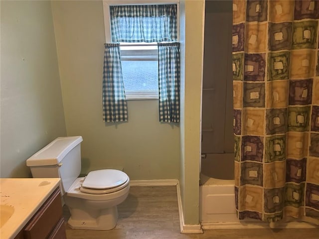 full bath featuring toilet, wood finished floors, vanity, and baseboards