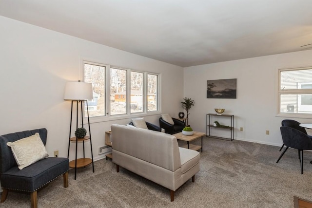 carpeted living room featuring baseboards and a wealth of natural light