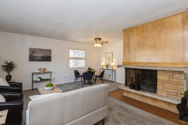 living area featuring carpet, ceiling fan, a fireplace, and baseboards