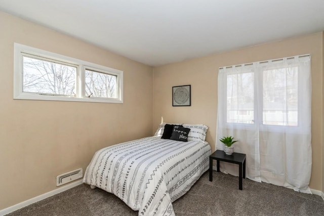 bedroom with dark colored carpet, visible vents, and baseboards