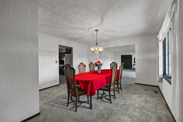 dining room with carpet floors, baseboards, and a chandelier