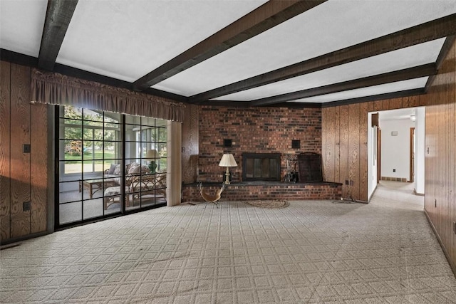 unfurnished living room featuring beamed ceiling, wood walls, and a fireplace