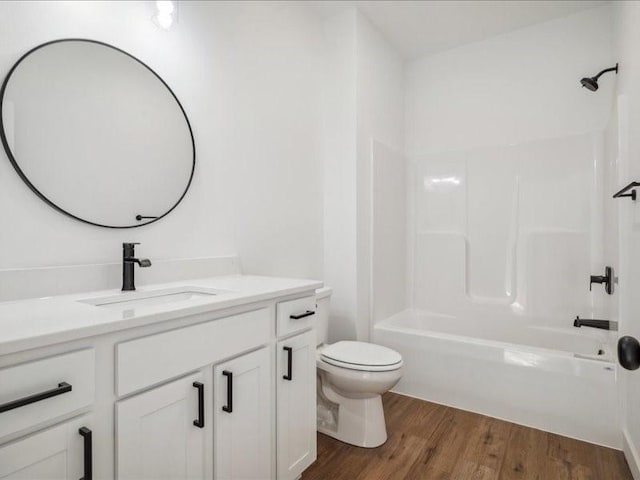 bathroom featuring  shower combination, vanity, toilet, and wood finished floors