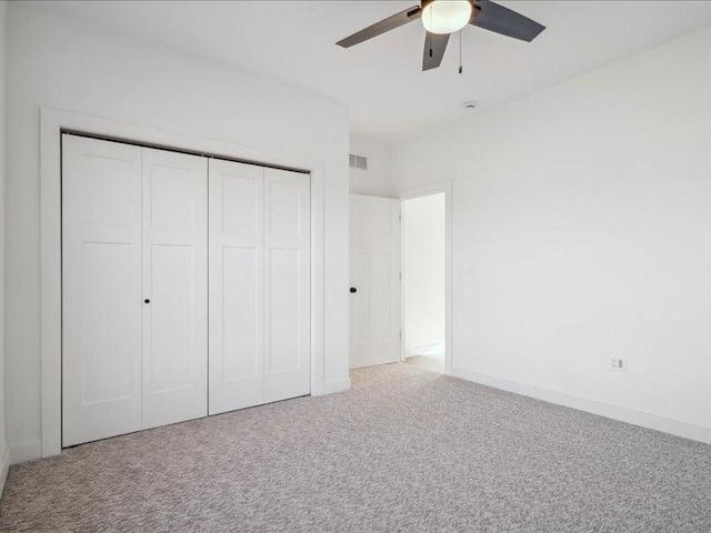 unfurnished bedroom with baseboards, visible vents, a ceiling fan, carpet flooring, and a closet