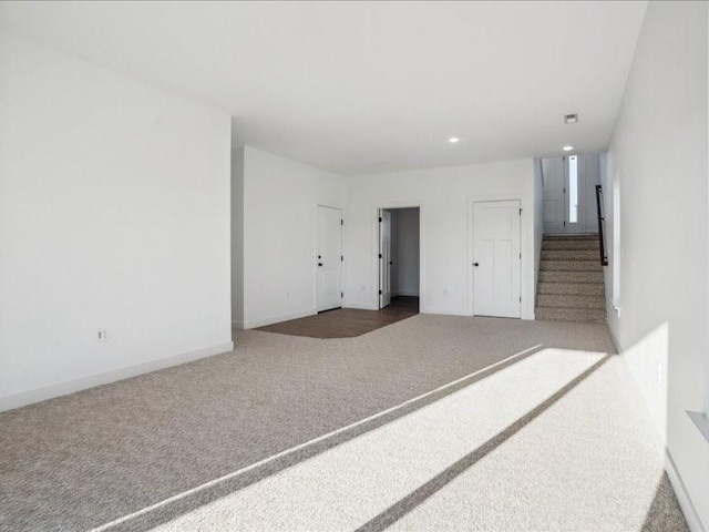 empty room featuring stairs, recessed lighting, carpet flooring, and baseboards