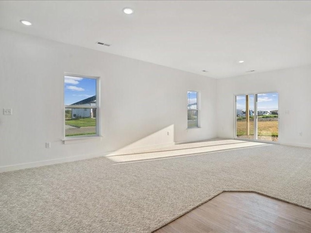 carpeted spare room with recessed lighting, visible vents, and baseboards