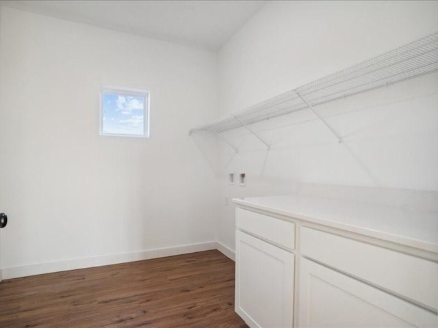 laundry room featuring laundry area, baseboards, and dark wood-type flooring