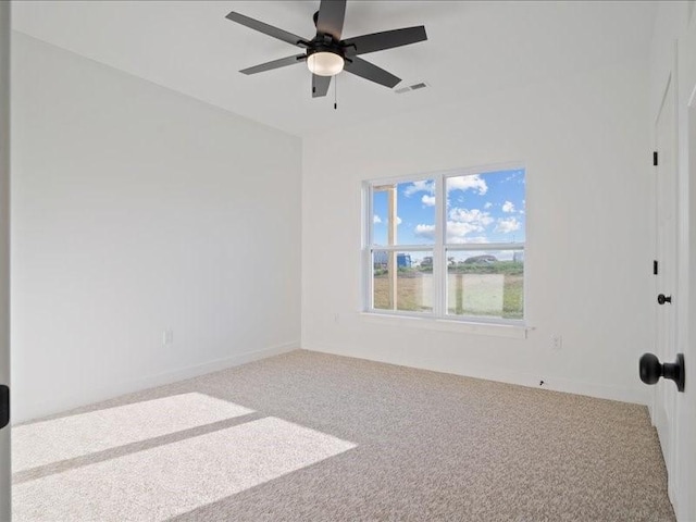carpeted empty room featuring visible vents and ceiling fan