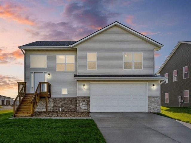 view of front of home with an attached garage, driveway, stone siding, and a front yard