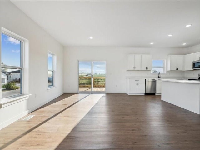 unfurnished living room with dark wood-style floors, recessed lighting, visible vents, and baseboards