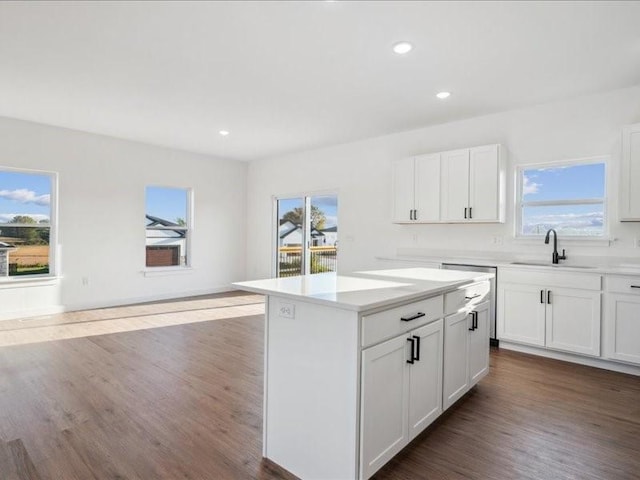 kitchen featuring dark wood-style floors, white cabinetry, light countertops, and a sink