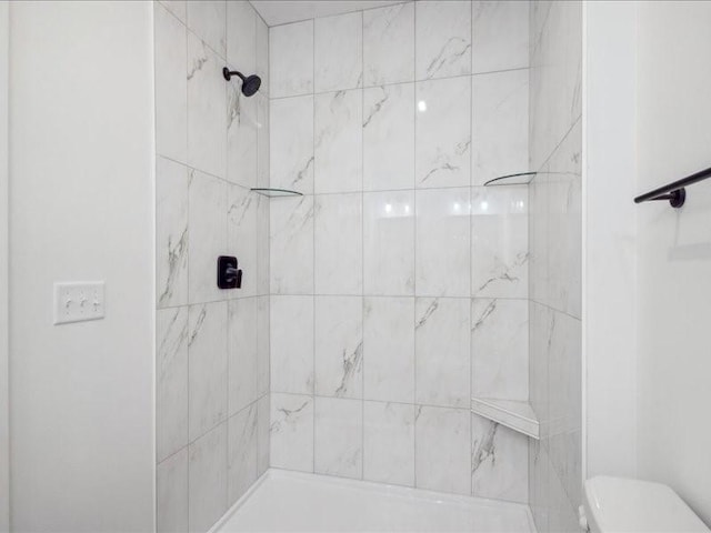 full bathroom with toilet and a tile shower