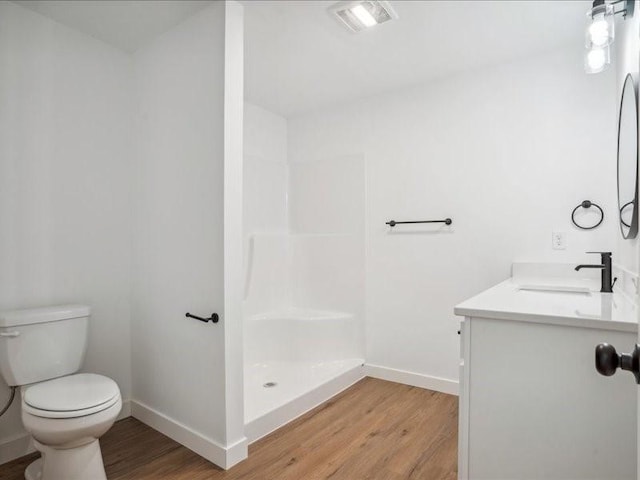 bathroom featuring toilet, wood finished floors, visible vents, baseboards, and walk in shower