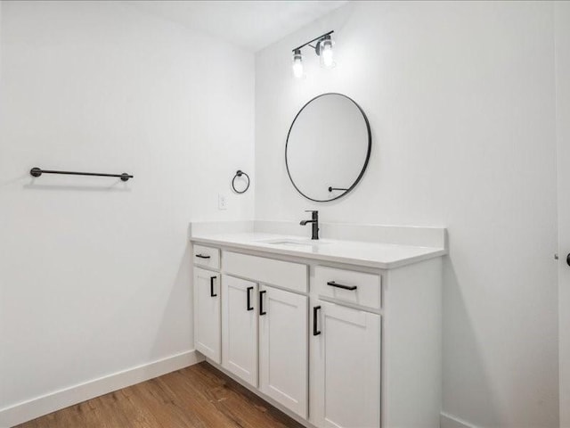 bathroom with baseboards, wood finished floors, and vanity