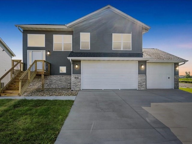 view of front of property featuring an attached garage, concrete driveway, and stone siding