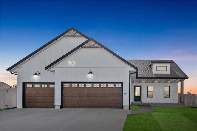 modern inspired farmhouse with roof with shingles, driveway, an attached garage, and fence