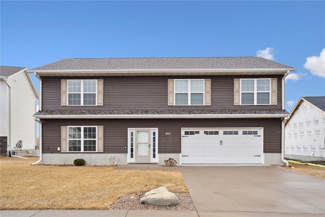 view of front of property with a garage, driveway, roof with shingles, and a front yard