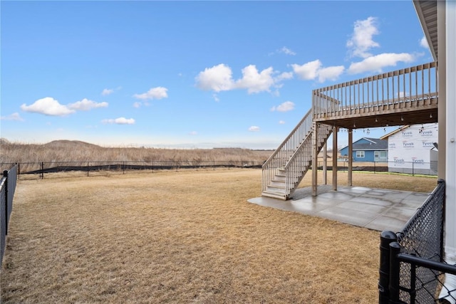 view of yard with a patio area, fence, stairway, and a wooden deck