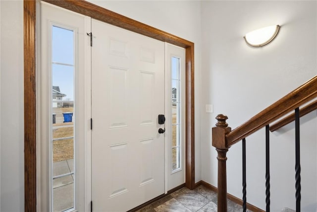 entrance foyer with stairway, baseboards, and light tile patterned floors