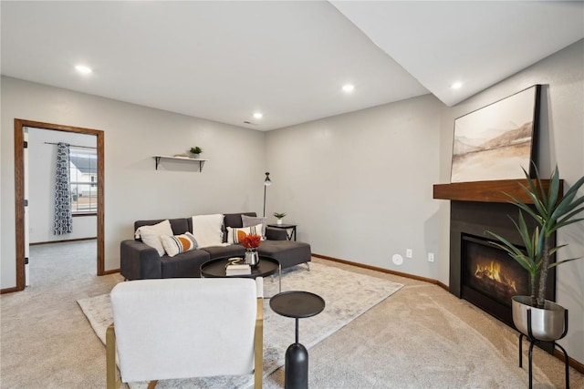 carpeted living room with recessed lighting, baseboards, and a glass covered fireplace