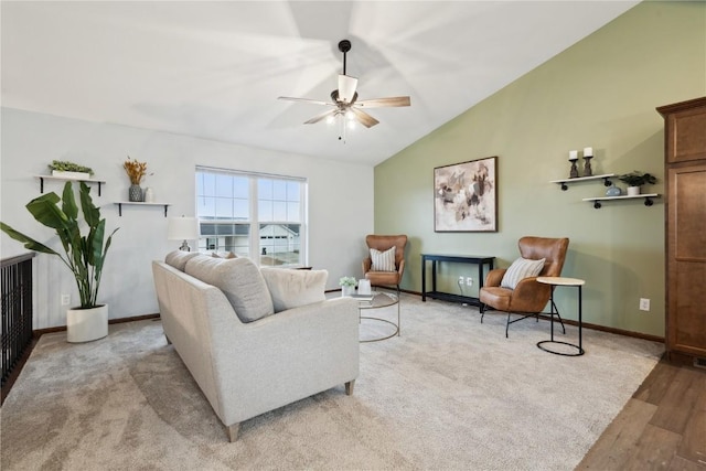 living area with lofted ceiling, ceiling fan, light wood-style flooring, light colored carpet, and baseboards