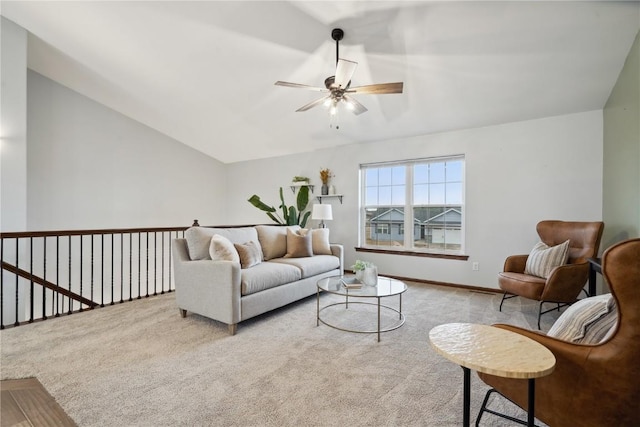 carpeted living area featuring baseboards, vaulted ceiling, and a ceiling fan