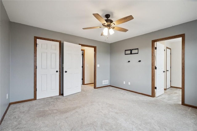 unfurnished bedroom with visible vents, baseboards, a ceiling fan, and light colored carpet