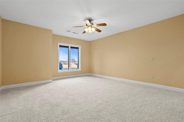 unfurnished room with light carpet, ceiling fan, visible vents, and baseboards