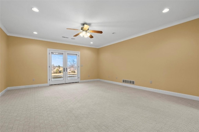 empty room with french doors, crown molding, visible vents, light carpet, and baseboards