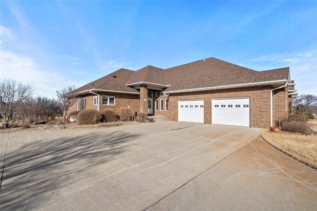 view of front of property with concrete driveway, brick siding, an attached garage, and a shingled roof