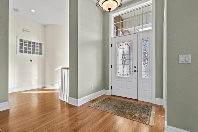 foyer featuring a high ceiling, baseboards, and wood finished floors