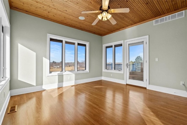 spare room with wooden ceiling, visible vents, wood finished floors, and ornamental molding