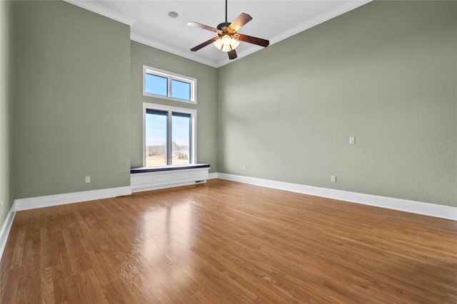 unfurnished room with crown molding, ceiling fan, wood finished floors, and baseboards