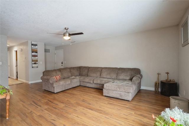 living area featuring light wood finished floors, visible vents, and baseboards