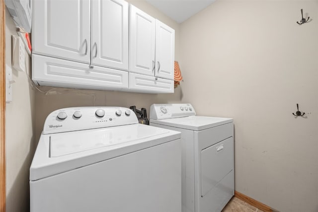 washroom featuring cabinet space, washer and clothes dryer, and baseboards