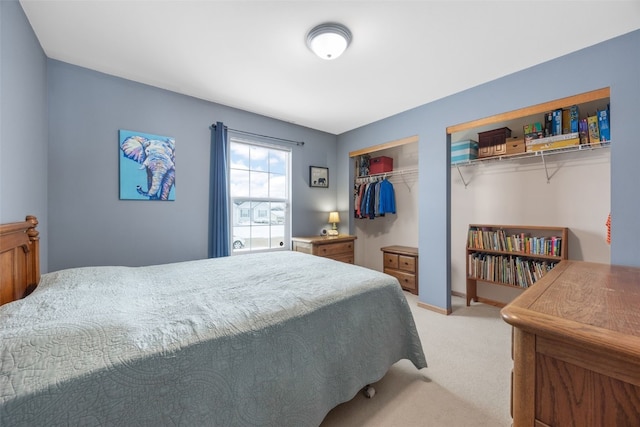 carpeted bedroom with multiple closets and baseboards