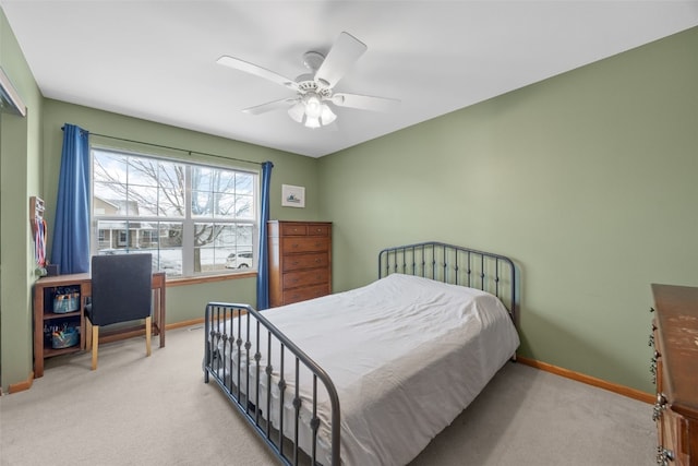 carpeted bedroom with ceiling fan and baseboards