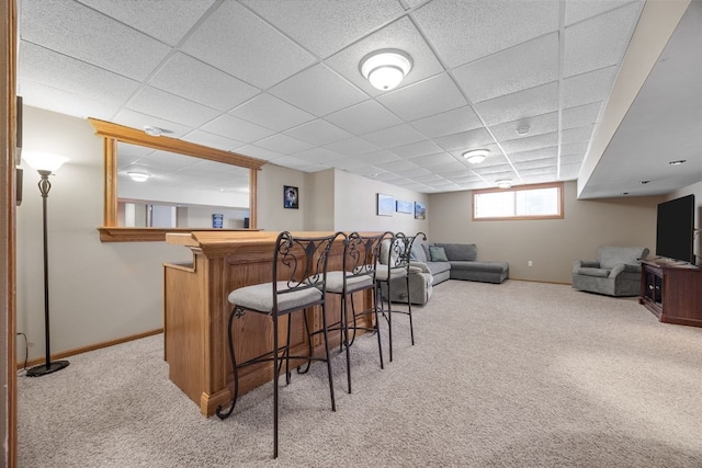 bar with baseboards, light carpet, a drop ceiling, and a dry bar