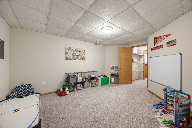 recreation room featuring carpet floors, baseboards, and a drop ceiling