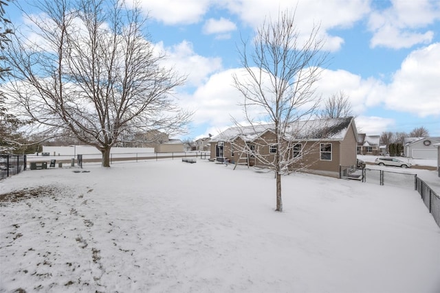 snowy yard with a fenced backyard and a residential view