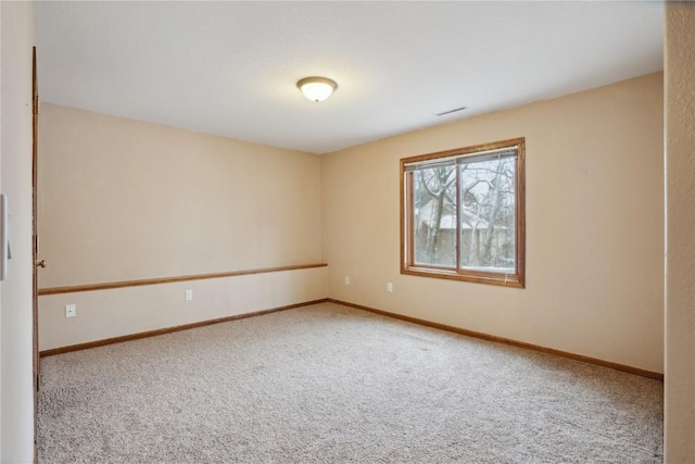 carpeted spare room featuring baseboards