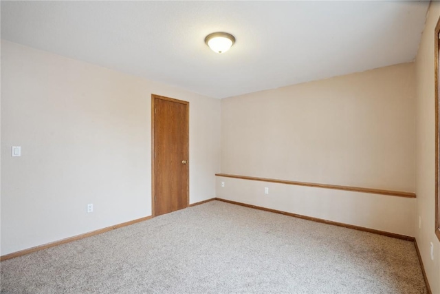 carpeted spare room featuring baseboards