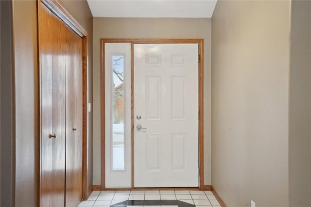 foyer entrance featuring plenty of natural light, light tile patterned flooring, and baseboards