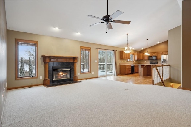 unfurnished living room featuring baseboards, vaulted ceiling, a tiled fireplace, and light colored carpet