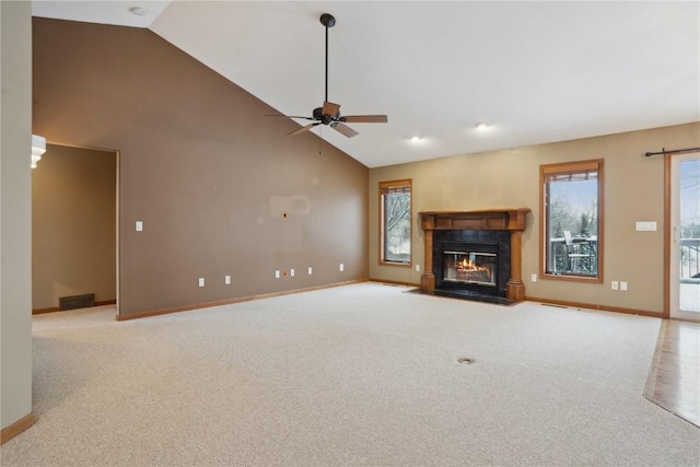 unfurnished living room featuring visible vents, baseboards, a fireplace with flush hearth, carpet floors, and high vaulted ceiling